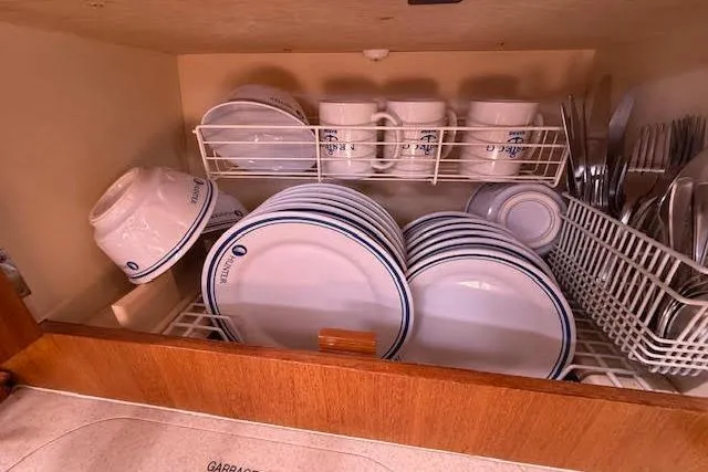  Yacht Photos Pics Cabinet with neatly arranged plates, bowls, mugs, and cutlery on a Hunter 38, 2005 model.
