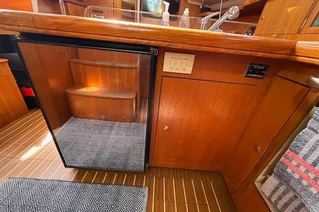  Yacht Photos Pics Interior of 2005 Hunter 38 yacht with wooden cabinetry and compact fridge.
