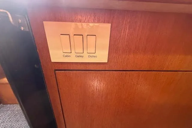  Yacht Photos Pics Light switches on a wooden panel in a 2005 Hunter 38 yacht interior.