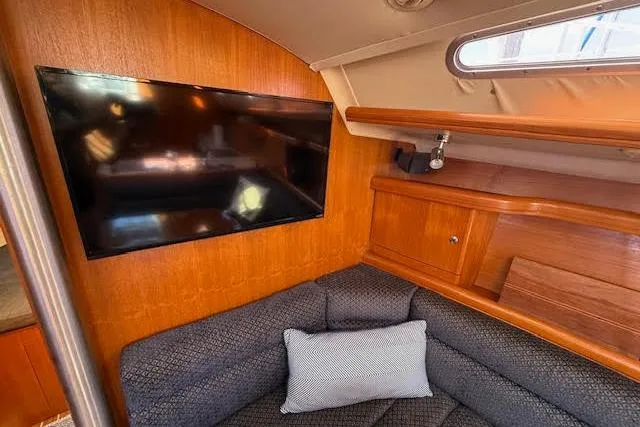  Yacht Photos Pics Interior of 2005 Hunter 38 yacht with TV, sofa, and wooden cabinetry.