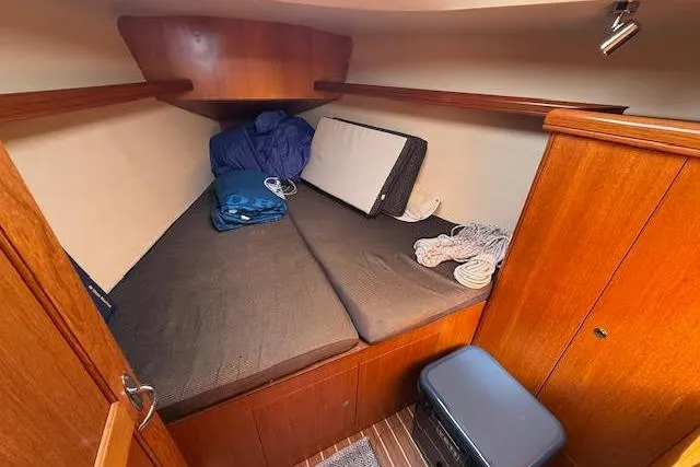  Yacht Photos Pics 2005 Hunter 38 sailboat cabin with wooden interior and cozy sleeping area.