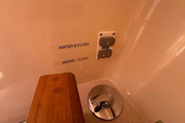  Yacht Photos Pics Control panel in a 2005 Hunter 38 yacht bathroom with water and flush buttons.