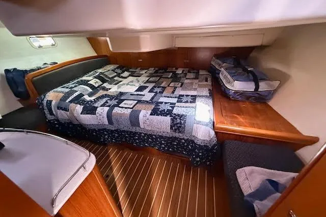  Yacht Photos Pics Cozy cabin interior of 2005 Hunter 38 sailboat with quilted bed and wooden accents.