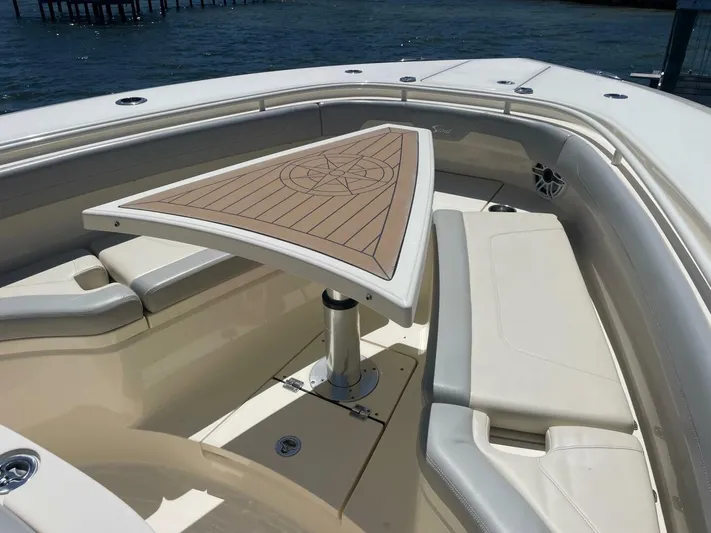 Exit Strategy Yacht Photos Pics 2020 Scout 355 LXF Center Console boat with cushioned seating and triangular table.
