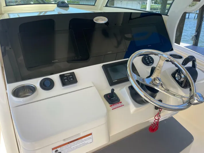 Exit Strategy Yacht Photos Pics 2020 Scout 355 LXF Center Console helm with steering wheel and navigation screens.
