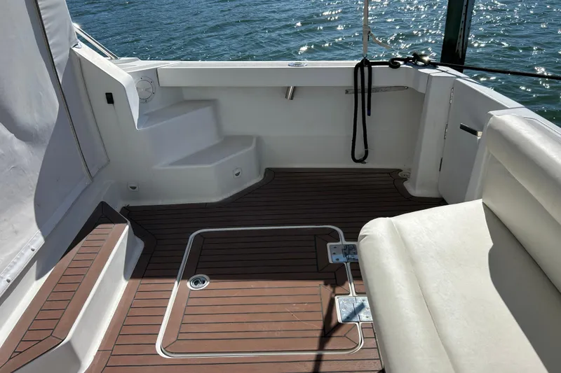 Solitude Yacht Photos Pics 2008 Back Cove 33 boat deck with wooden flooring and white seating, overlooking water.