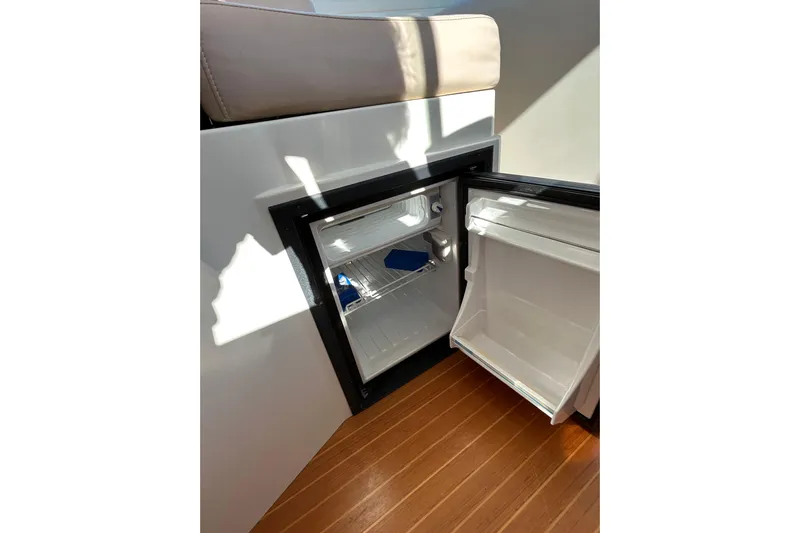 Solitude Yacht Photos Pics Open mini fridge on 2008 Back Cove 33 boat, showing interior shelves and wooden flooring.