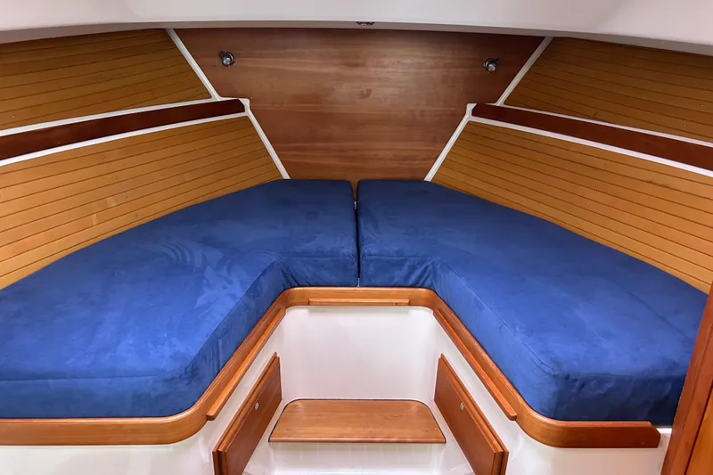 Solitude Yacht Photos Pics 2008 Back Cove 33 boat interior with blue cushions and wooden paneling.