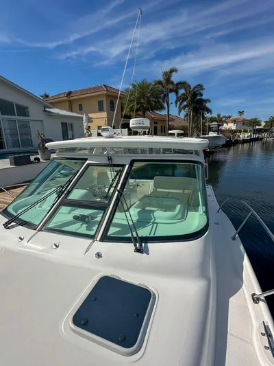  Yacht Photos Pics 2006 Tiara Yachts 3200 Open docked near waterfront homes under clear skies.