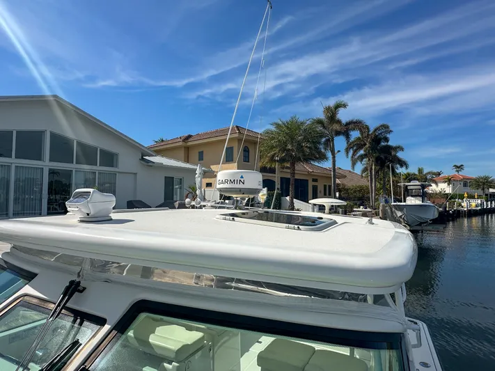  Yacht Photos Pics 2006 Tiara Yachts 3200 Open docked near waterfront homes under a clear blue sky.