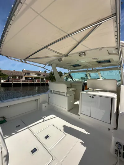  Yacht Photos Pics 2006 Tiara Yachts 3200 Open boat interior with seating and canopy, docked by waterfront homes.