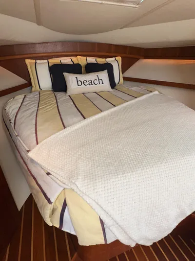  Yacht Photos Pics Cozy cabin interior of 2006 Tiara Yachts 3200 Open with striped bedding and "beach" pillow.