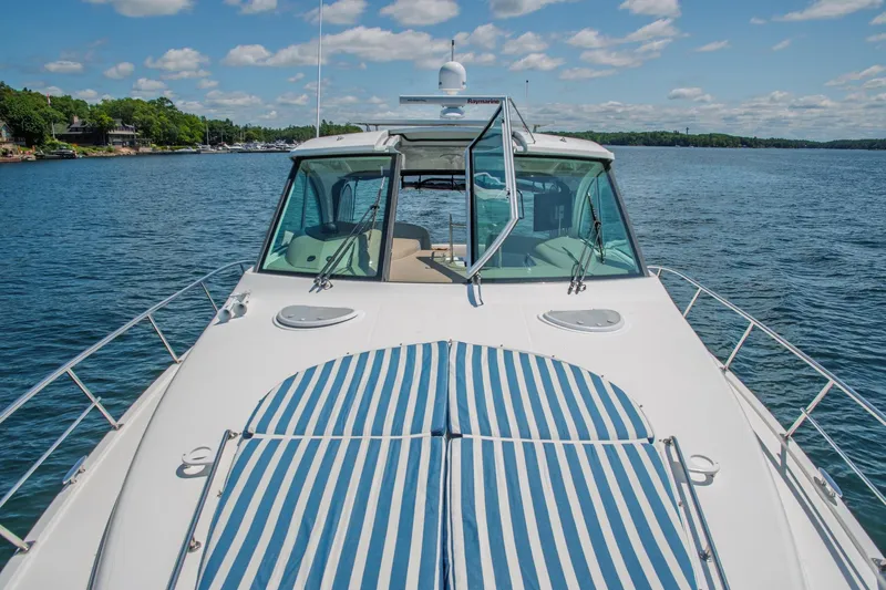  Yacht Photos Pics 2011 Cruisers Yachts 420 Sport Coupe on a serene lake under a blue sky.