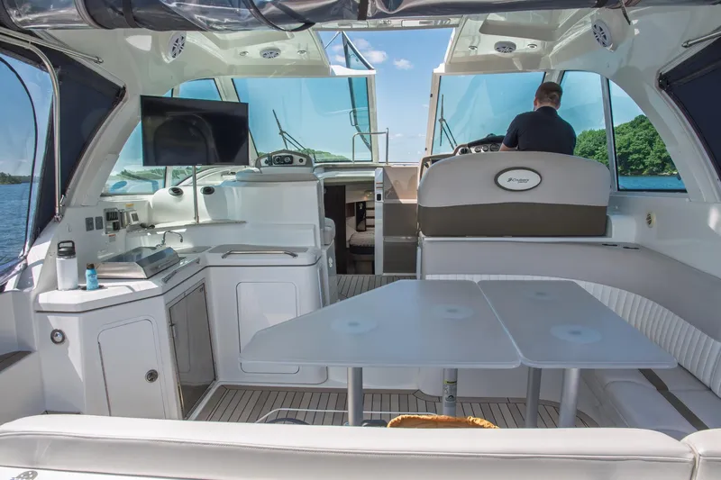  Yacht Photos Pics 2011 Cruisers Yachts 420 Sport Coupe interior with helm, seating, and kitchenette on a sunny day.