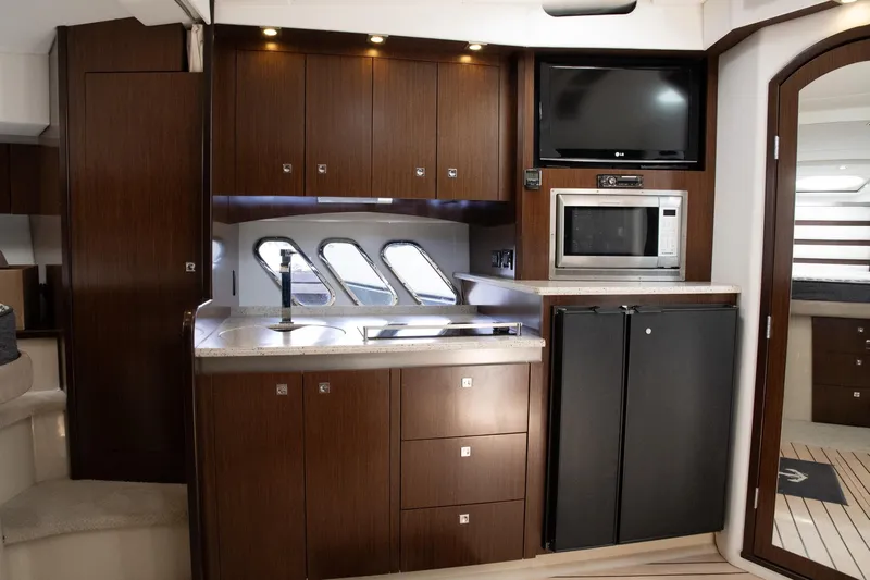  Yacht Photos Pics Luxurious interior of 2011 Cruisers Yachts 420 Sport Coupe with modern kitchen amenities.