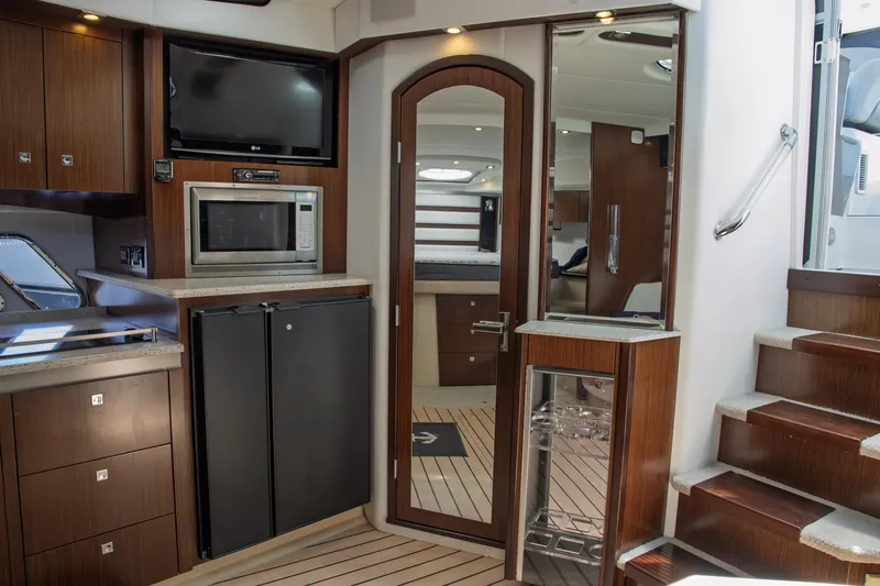  Yacht Photos Pics 2011 Cruisers Yachts 420 Sport Coupe interior with kitchen, microwave, fridge, and stairs.