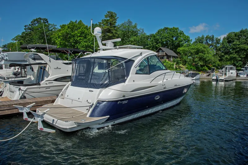  Yacht Photos Pics 2011 Cruisers Yachts 420 Sport Coupe docked in a marina, surrounded by lush greenery.