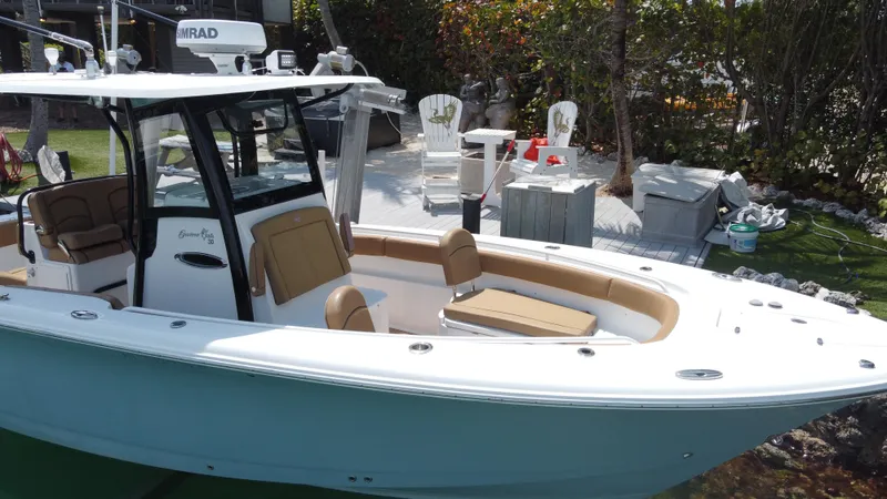  Yacht Photos Pics 2020 Sea Hunt Gamefish 30 boat with forward seating, docked near a garden area.