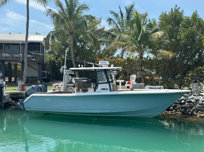  Yacht Photos Pics 2020 Sea Hunt Gamefish 30 boat docked, surrounded by palm trees and clear water.
