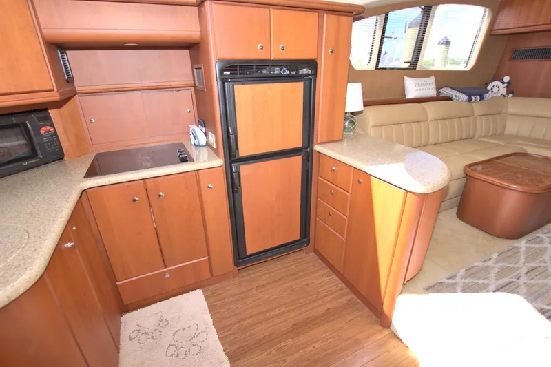 Bear Foot II Yacht Photos Pics 2006 Silverton 39 Motor Yacht interior with kitchen and seating area, featuring wood cabinetry and flooring.