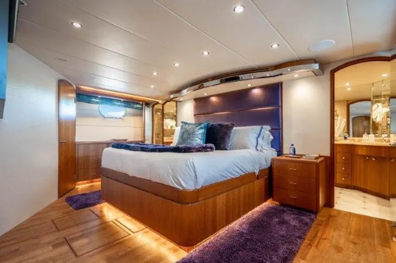Claire Yacht Photos Pics Luxurious bedroom interior of 2003 Hatteras 100 yacht with elegant wood finishes and plush bedding.