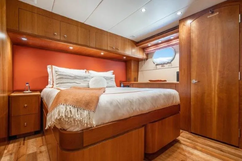 Claire Yacht Photos Pics Luxurious cabin interior of a 2003 Hatteras 100 yacht with wood finishes and cozy bedding.