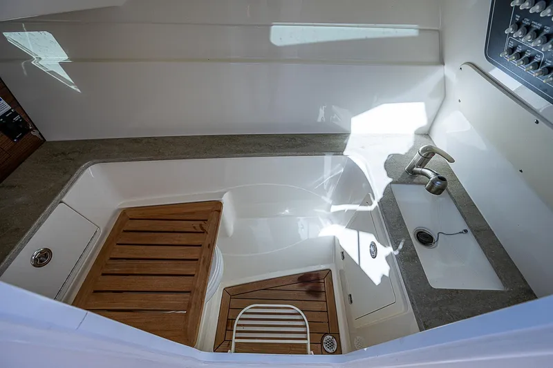  Yacht Photos Pics 2018 Boston Whaler 320 Vantage boat interior with sink and wooden accents.