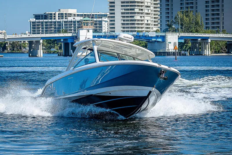  Yacht Photos Pics 2018 Boston Whaler 320 Vantage cruising on water near a city bridge.