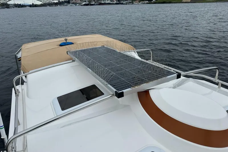 C Shell Yacht Photos Pics 2022 Ranger Tugs R-27 boat with solar panel on deck, docked on calm water.