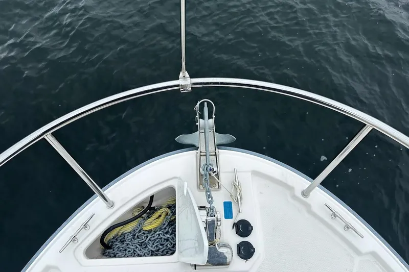 C Shell Yacht Photos Pics Bow of 2022 Ranger Tugs R-27 with anchor and chain over water.