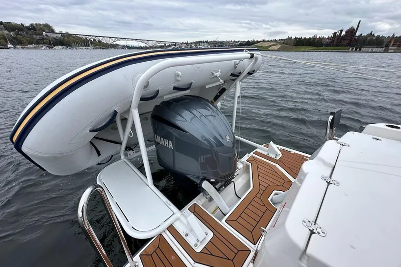 C Shell Yacht Photos Pics 2022 Ranger Tugs R-27 with Yamaha engine and inflatable boat on water.