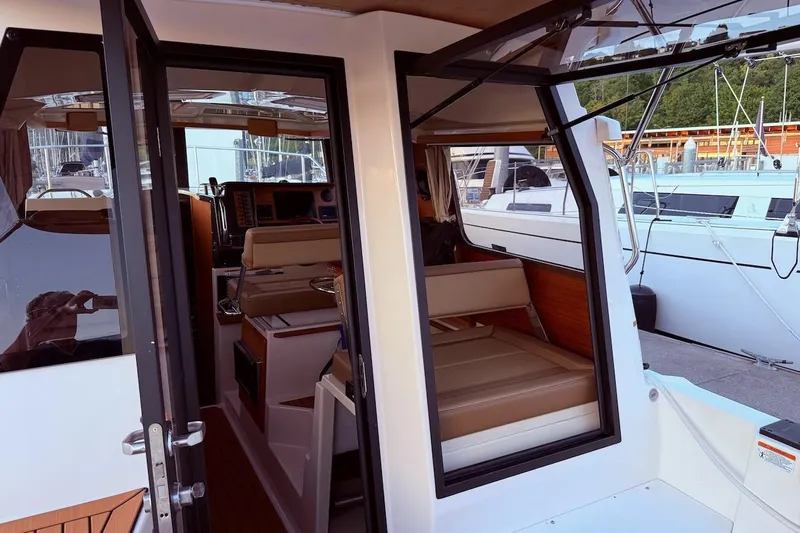 C Shell Yacht Photos Pics Interior view of 2022 Ranger Tugs R-27 boat, showcasing seating and helm area.