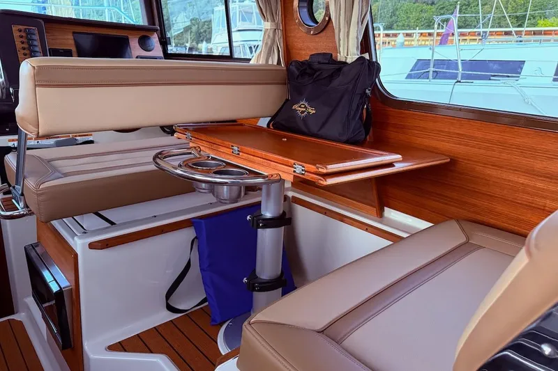 C Shell Yacht Photos Pics Interior of 2022 Ranger Tugs R-27 with seating, table, and window view.