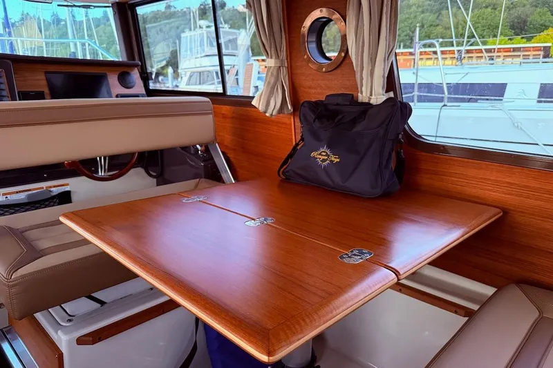 C Shell Yacht Photos Pics Interior of 2022 Ranger Tugs R-27 with wooden table and seating.