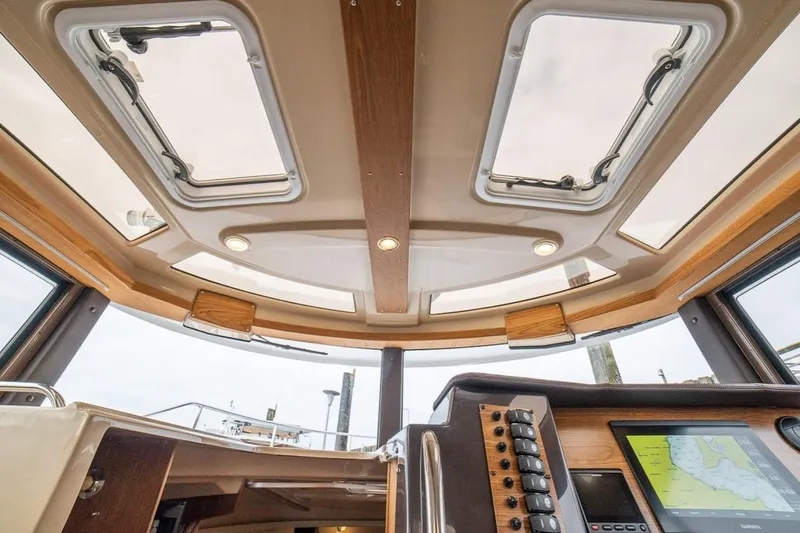 C Shell Yacht Photos Pics Interior view of 2022 Ranger Tugs R-27 boat, featuring skylights and navigation controls.