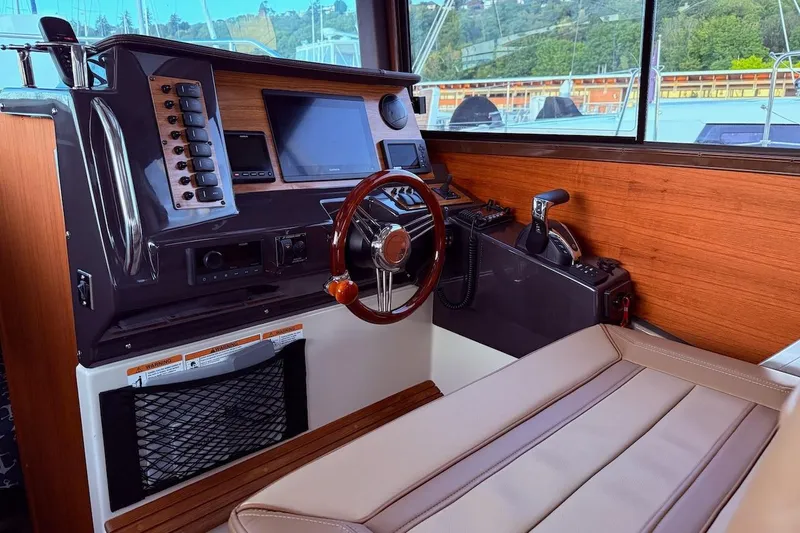 C Shell Yacht Photos Pics 2022 Ranger Tugs R-27 helm with modern controls and wood accents.