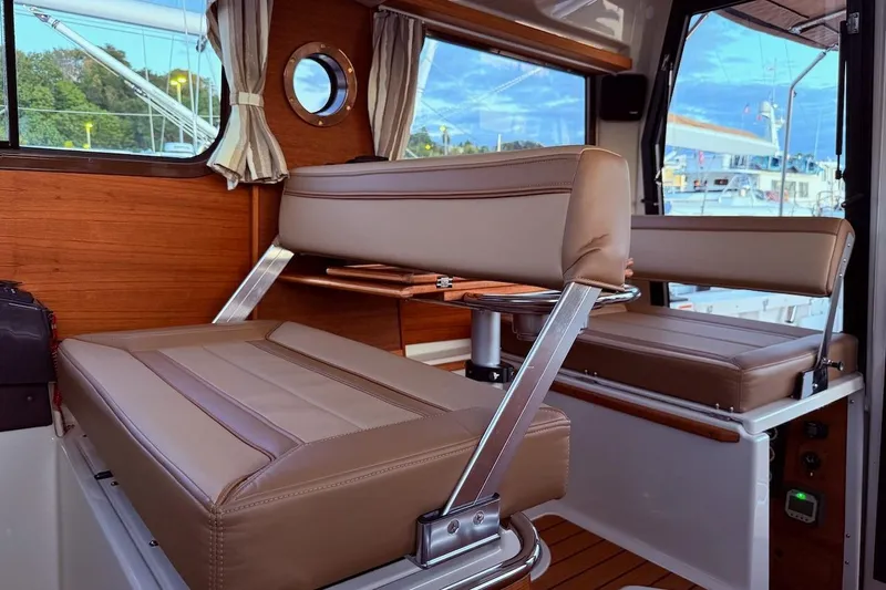 C Shell Yacht Photos Pics Interior of 2022 Ranger Tugs R-27 with brown leather seating and wood accents.