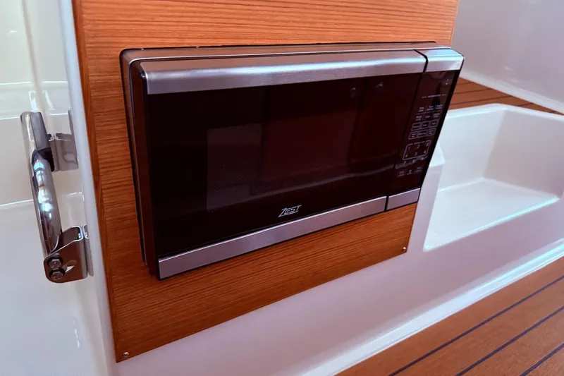 C Shell Yacht Photos Pics Microwave in 2022 Ranger Tugs R-27 boat interior, featuring wood paneling and sleek design.