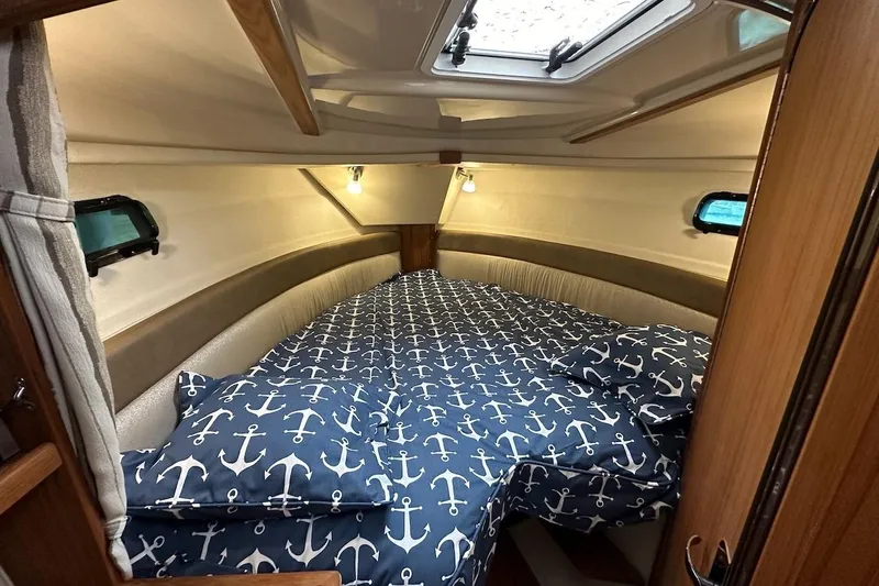 C Shell Yacht Photos Pics Cozy cabin interior of 2022 Ranger Tugs R-27 with nautical-themed bedding.