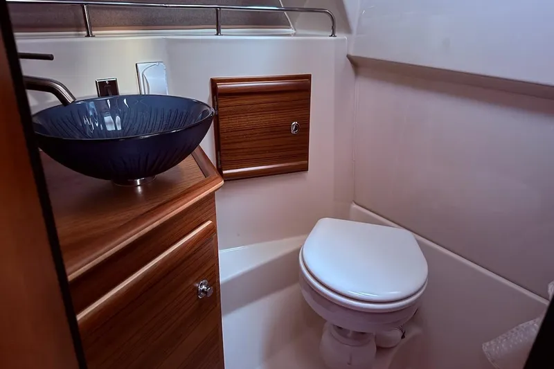 C Shell Yacht Photos Pics 2022 Ranger Tugs R-27 boat bathroom with modern sink and wooden cabinetry.