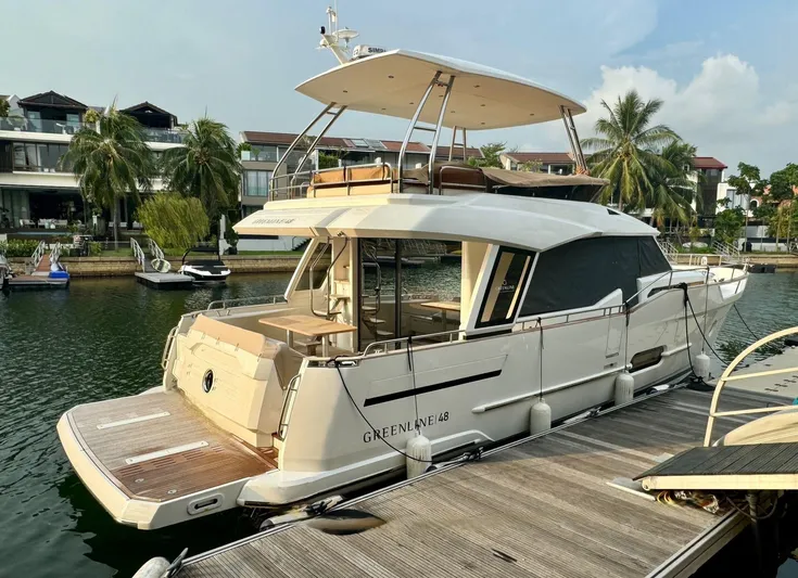  Yacht Photos Pics 2024 Greenline 48 Fly yacht docked by waterfront homes, showcasing luxury and modern design.