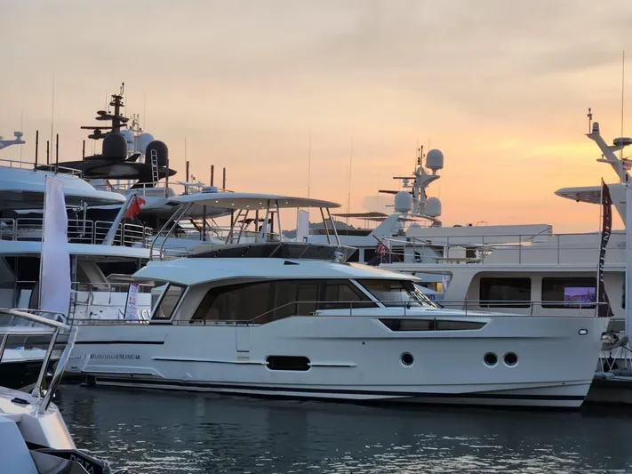  Yacht Photos Pics 2024 Greenline 48 Fly yacht docked at sunset, surrounded by other luxury boats.