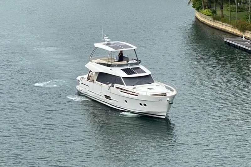  Yacht Photos Pics 2024 Greenline 48 Fly yacht cruising on a calm waterway.