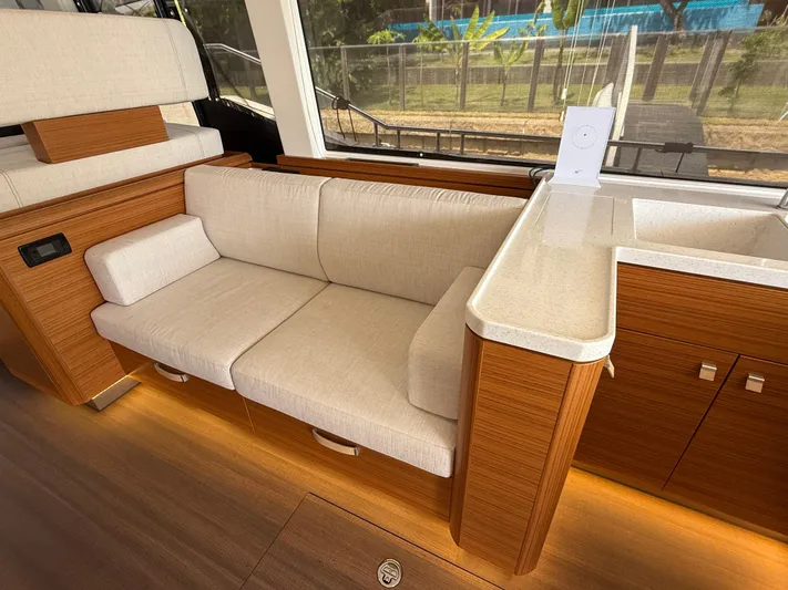  Yacht Photos Pics Luxurious interior of 2024 Greenline 48 Fly yacht with beige sofa and wooden cabinetry.