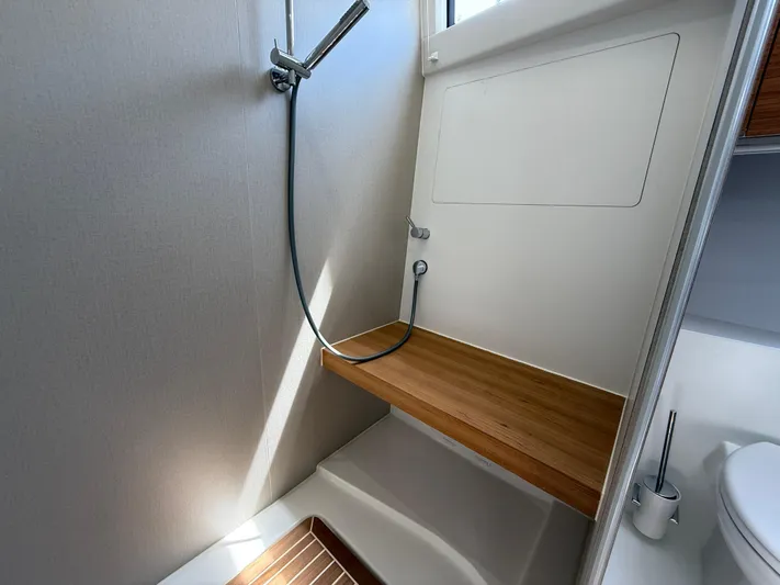 Yacht Photos Pics Modern shower area in 2024 Greenline 48 Fly yacht with wooden bench and sleek fixtures.