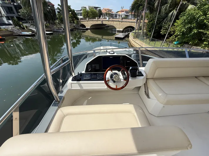  Yacht Photos Pics 2024 Greenline 48 Fly yacht helm with luxurious seating and scenic canal view.
