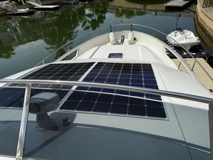  Yacht Photos Pics 2024 Greenline 48 Fly yacht with solar panels on deck, docked in a serene marina.