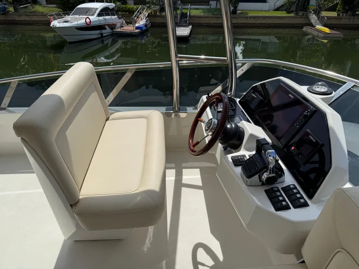  Yacht Photos Pics 2024 Greenline 48 Fly yacht helm with beige seating and modern controls.