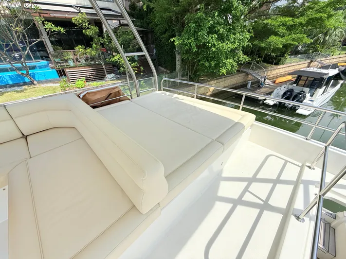  Yacht Photos Pics Luxurious seating area on 2024 Greenline 48 Fly yacht, docked by lush greenery.