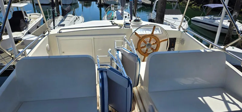 Grand Finale Yacht Photos Pics 1991 Grand Banks 36 Classic yacht interior with wooden steering wheel and seating area.